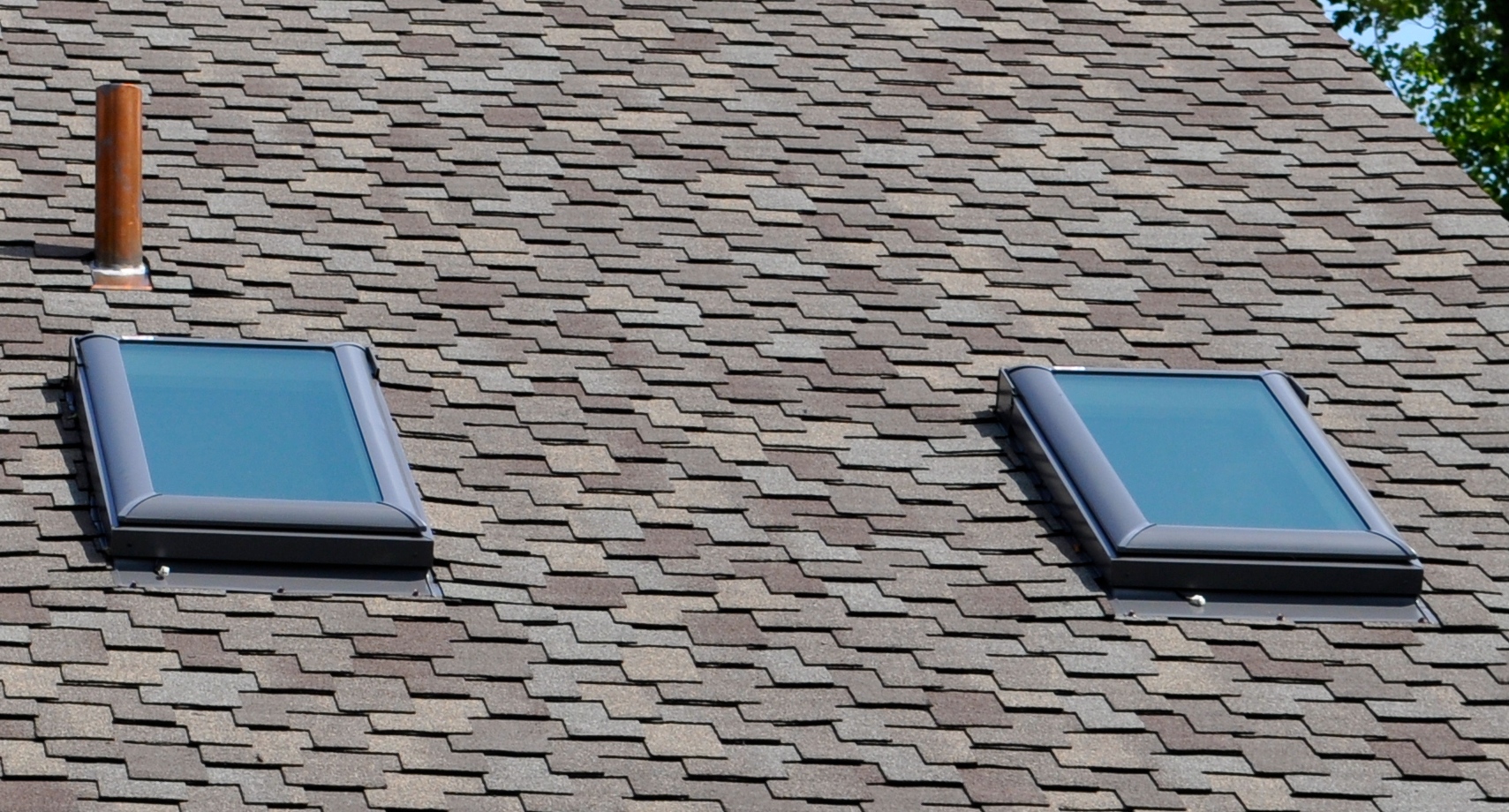 Asphalt shingle roof with two installed skylights